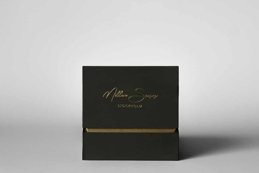Elegant black box with gold lettering on white background