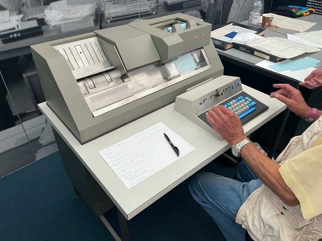 a person sitting at a desk with a computer and papers